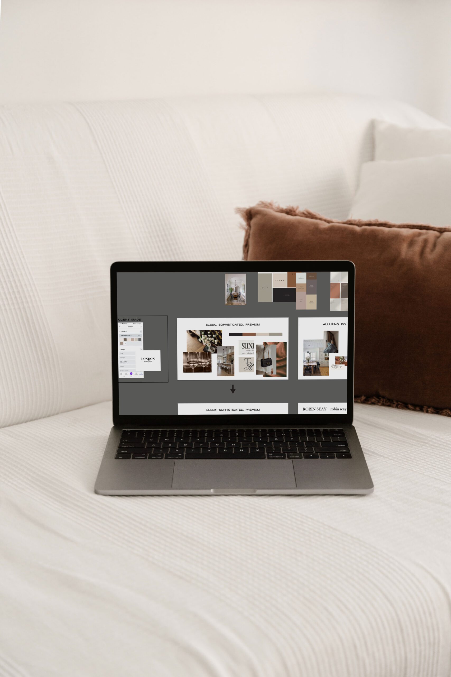 Open laptop showing mood board for brand design for realtor on a couch